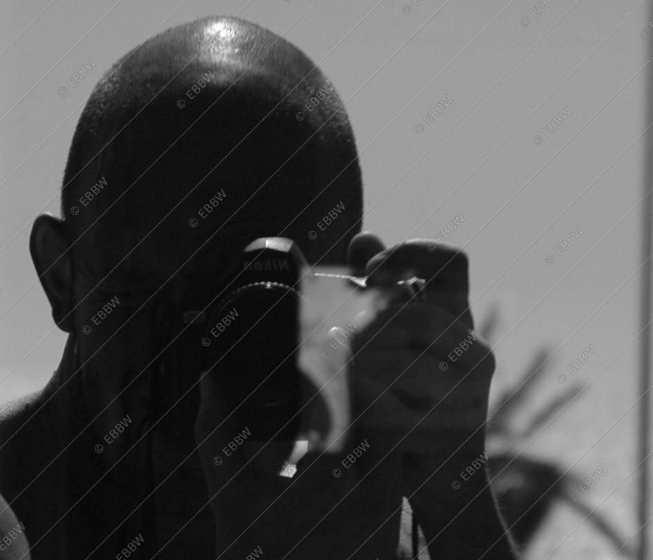 Autoportrait d’Éric Branca dans un miroir, appareil photo devant le visage