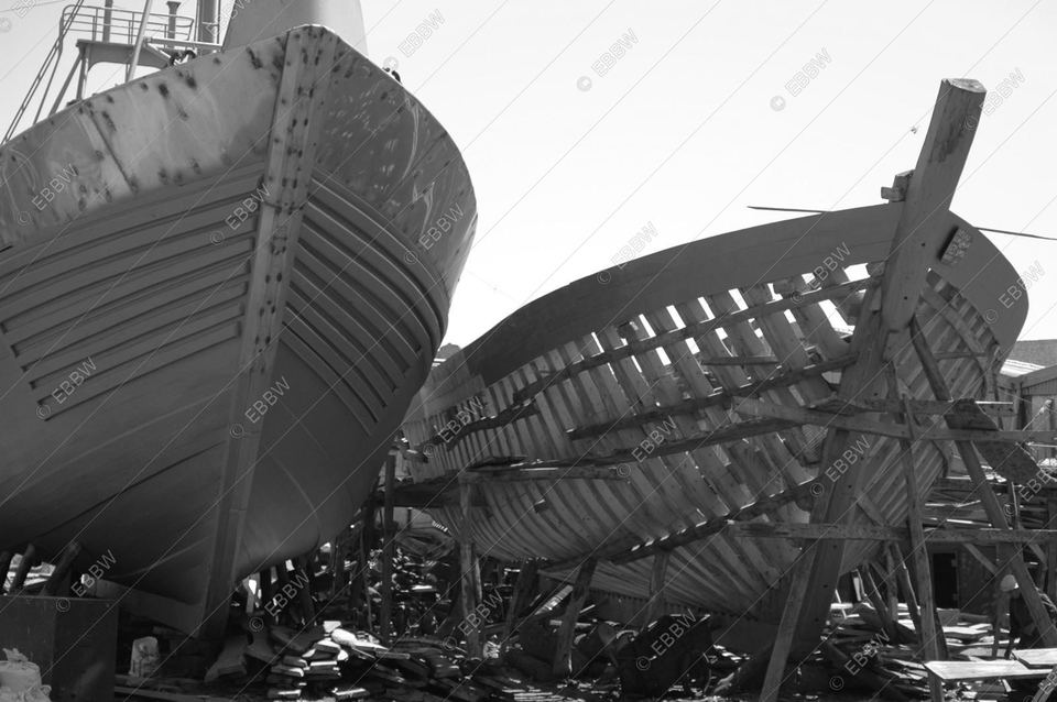 Coques de bateaux en bois en construction sur le sable