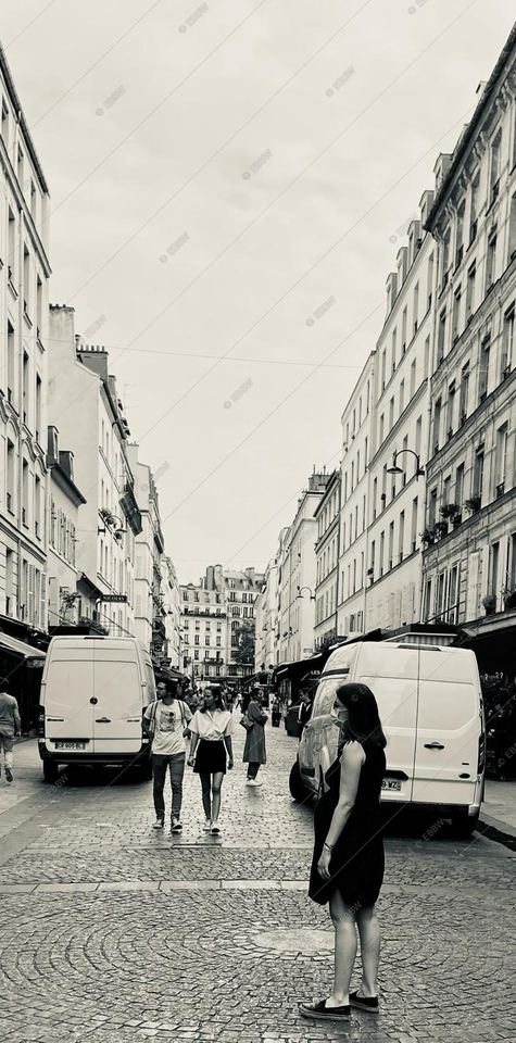 Rue pavée et passants entre deux rangées d’immeubles