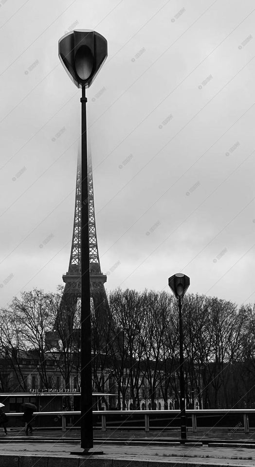 Tour métallique et lampadaire sous un ciel gris
