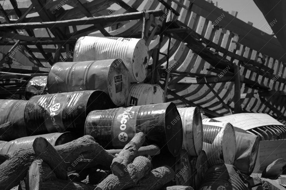 Bidons métalliques entassés sous une charpente