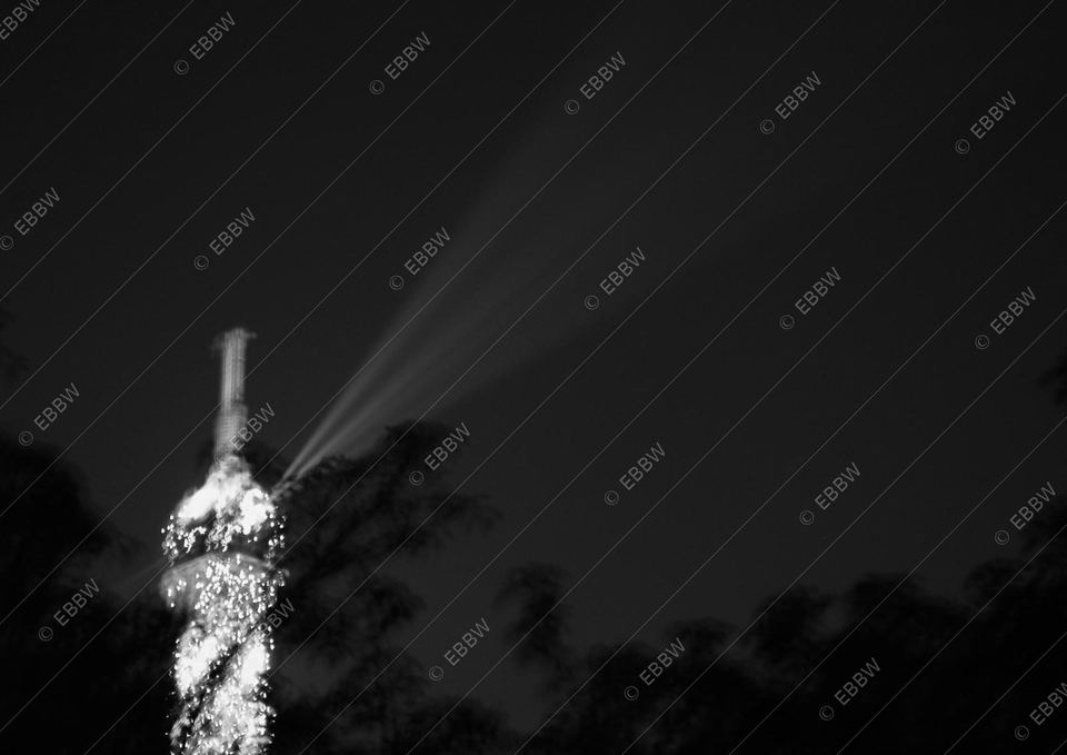 Sommet de la tour illuminé et son faisceau dans la nuit