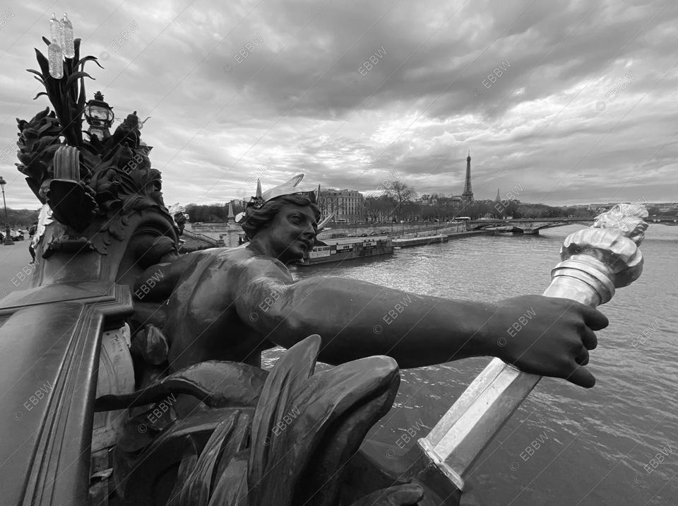 Statue de bronze tenant un flambeau au-dessus du fleuve