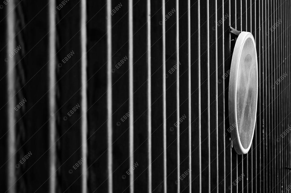 Grille de barreaux verticaux et disque lumineux